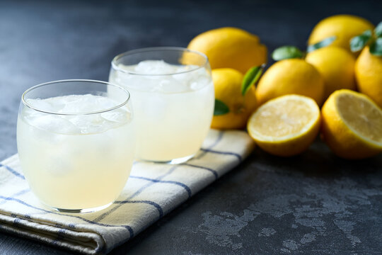 lemonade water with lemon slices , healthy and detox water drink with ice in summer on the dark kitchen table.