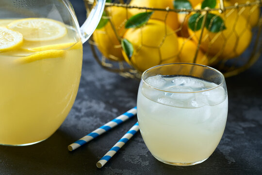Traditional homemade lemonade in glass with ice on a black table, selective focus. Cold refreshing lemonade .