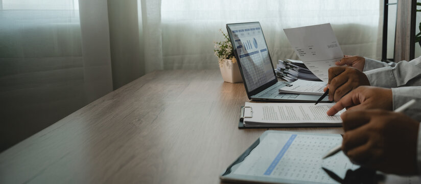 Business team consulting during a finance meeting, reviewing reports and dashboard data for partnership planning, teamwork and professional business decision making with wide copy space.