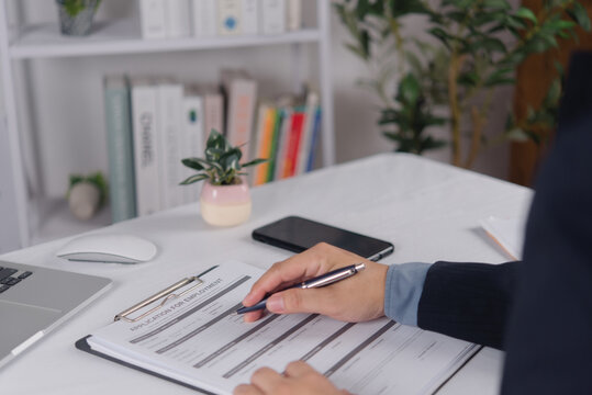 Job Application Form Completed at Office Desk with Laptop and Smartphone