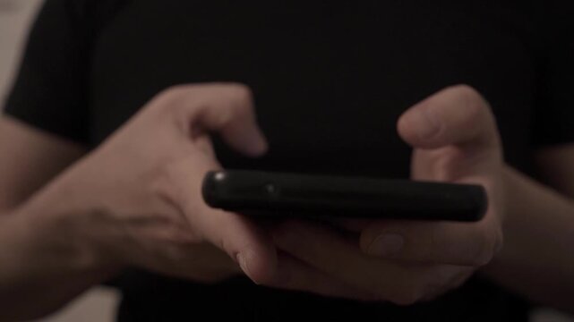 Close Up of Man Scrolling Social Media on Smartphone in Dark Room at Night