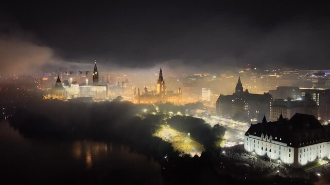Ottawa skyline at night with Parliament Hill, city lights, haze, smog and pollution above the Ottawa River. g.
