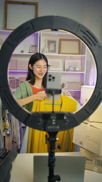 Asian woman Gen Z live streaming fashion clothing sales and looking at camera,social commerce influencer web broadcasting,e-business,e-commerce on entrepreneur,order confident,new business for gen Z
