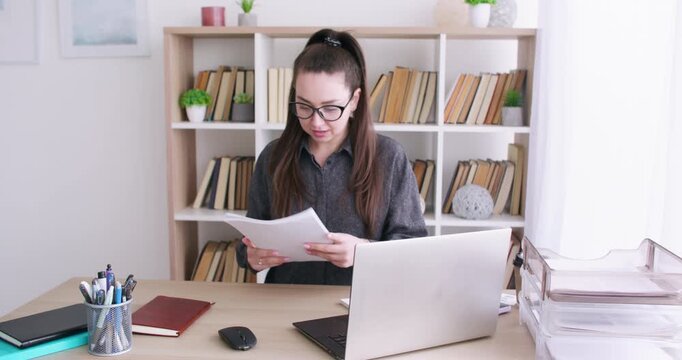 Paperwork failure. Business lifestyle. Annoyed female specialist at desk with laptop working with document at professional workplace.