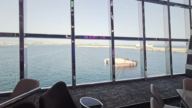 Slow move through aft lounge toward window view over Mediterranean harbor