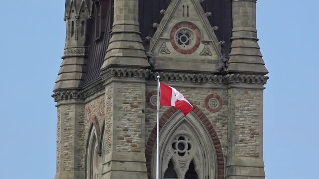Telephoto view of Canadian flag waving in front of the historic Peace Tower on Parliament Hill inOttawa, ON, Canada.