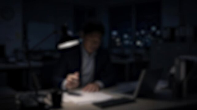 深夜残業でパソコンに向かい疲弊するビジネスパーソン