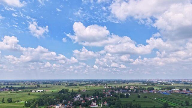 time-lapse, Aerial wide view of rural farmland, lake under blue sky with white clouds