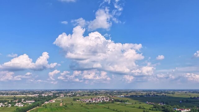 time-lapse, Aerial wide view of rural farmland, lake under blue sky with white clouds