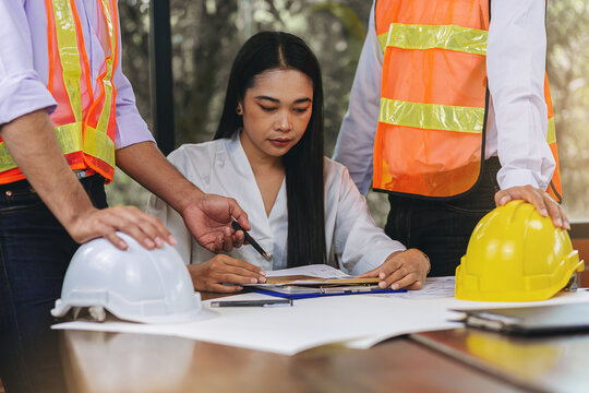 Structural engineer and architect with blueprints discuss and consulting customer, plan working for the house building construction project. Construction collaboration concept. Selected focus