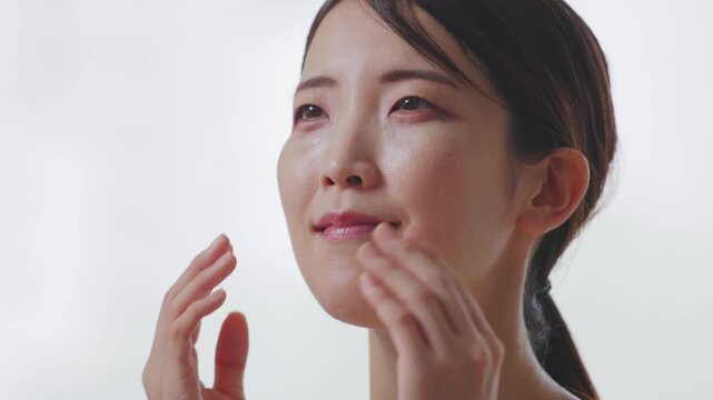 頬に手を添えて美肌をアピールする女性の横顔