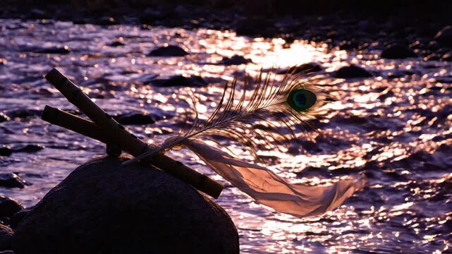 Traditional flute and peacock feather on stone at sunset with flowing river background perfect for Janmashtami festival celebration social media content and spiritual themes