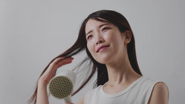 ドライヤーを使って髪を乾かす女性のローアングル