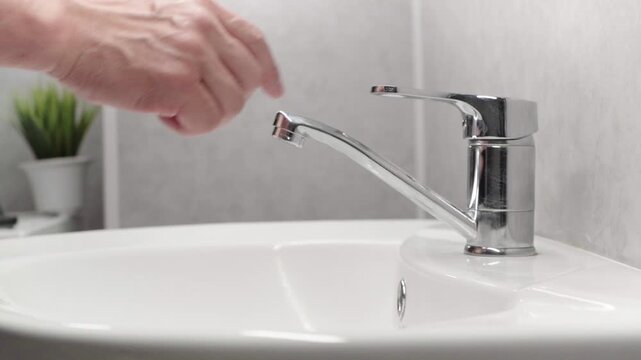 Hygiene. Hand cleaning. Washing hands with soap. Man washing his hands over a sink in the bathroom, close-up. Coronavirus.