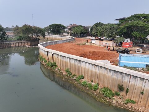 Aerial view of urban development with curved river, construction site, and residential housing Drone perspective of a developing cityscape featuring a winding river, earthworks, and scattered building