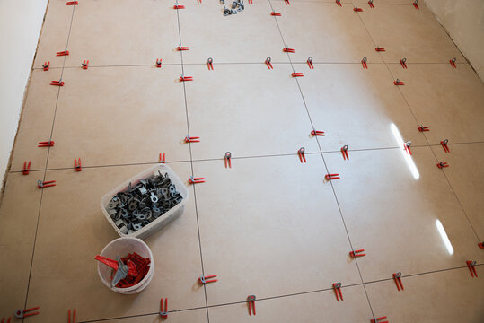 Laying large floor tiles using spacers. Home renovation work.