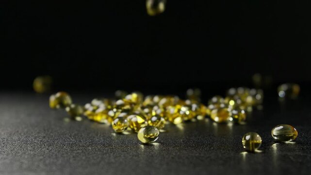 Softgel capsule falling and bouncing on a black tabletop