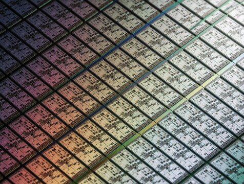 Close up view of many microchips on silicon wafer. Integrated circuit components arranged in grid pattern on semiconductor plate. Advanced tech hardware used in manufacturing process for digital