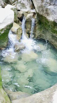 Small Waterfall Cascading Over Rocks into a Clear Basin