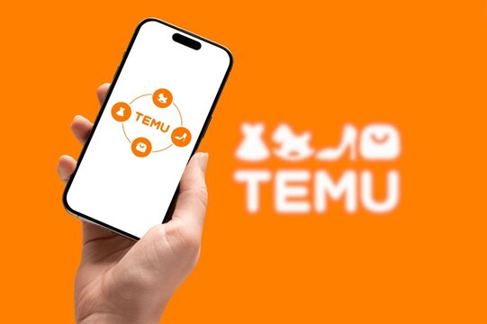 Hand holding mobile phone with TEMU logo on screen. Chinese e-commerce online marketplace. 10-JULY-2026-ADANA-TURKEY
