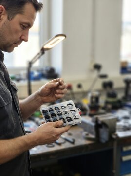 Mechanic Examining Precision Rubber Gaskets in an Industrial Workshop Setting for Automotive Repair and Mechanical Engineering Maintenance Tasks