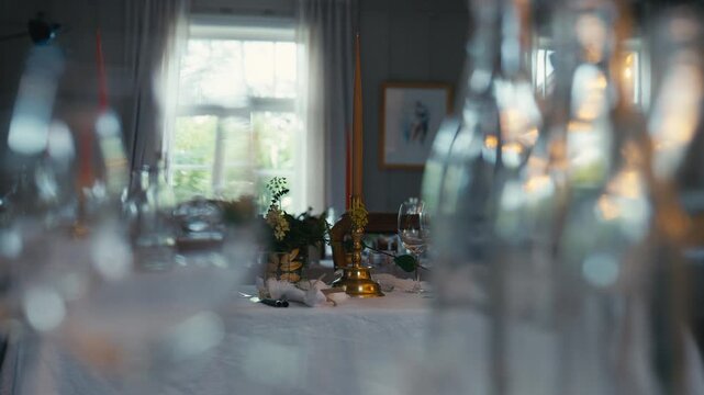 Shallow focus frames an elegantly set dining table with candles and glassware, creating an intimate atmosphere for celebrations and memorable gatherings.