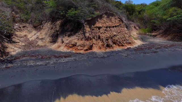 Dark Volcanic Sand Along A Tropical Coastal Shoreline At Playa Negra On Vieques Island, Puerto Rico. Aerial Sideways Shot