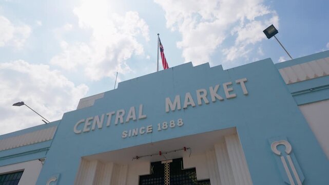 Vertical 4K 23.976 FPS slow-motion low angle shot of the historic Central Market (Pasar Seni) facade in Kuala Lumpur, Malaysia. Features the iconic blue Art Deco architecture and "Since 1888" signage.