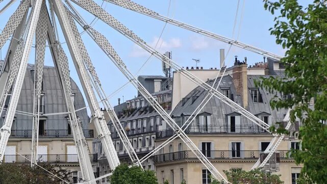 View Of The Ferris Wheel Structure And Historic Buildings At Fete Des Tuileries In Paris, France