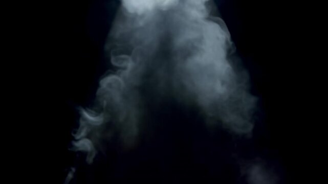 Smoke billowing upward in a dark environment, illuminated by a spotlight, creating a dramatic visual effect with swirling patterns and textures throughout the frames