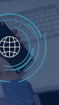 Animation of globe icon over caucasian businessman using smartphone in office