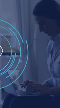 Animation of eye icon over caucasian businesswoman using laptop in office
