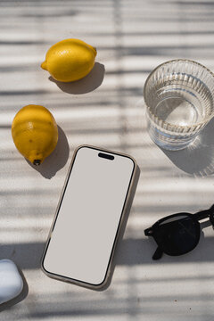 Minimalist Tech Mockup Featuring White Mobile Display Lemons And Earbuds Case