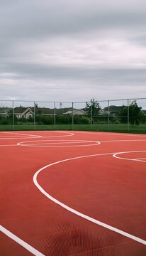 Solitude on a vibrant basketball court evokes peaceful moments within a quiet suburban landscape