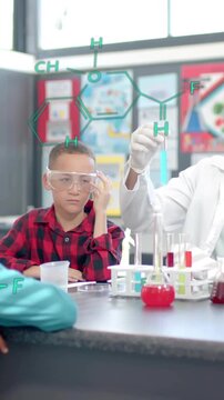 Chemistry formulas over teacher explaining experiment to children in science classroom