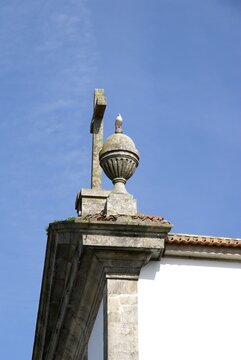 Stone cross with a bird on a church urn. Portugal - Norte