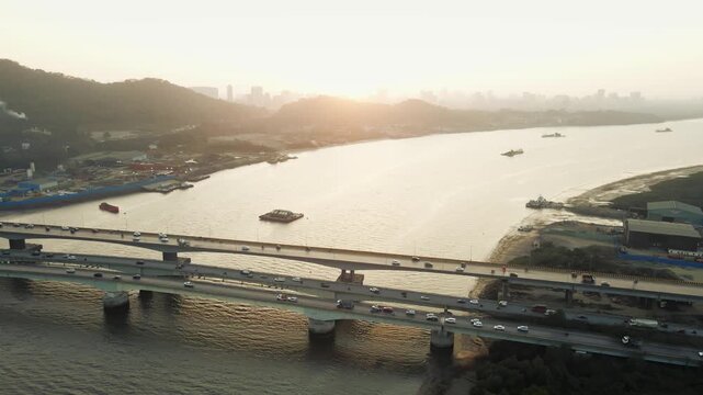 Aerial drone view of the Vasai Creek Bridge in Mumbai, India, spanning across the water and connecting key suburban regions. The scene captures vehicles moving along the bridge.