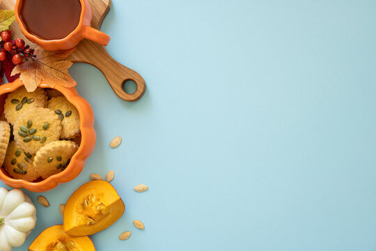 Cozy autumn snack scene with pumpkin cookie, warm tea and seasonal decorations welcoming fall