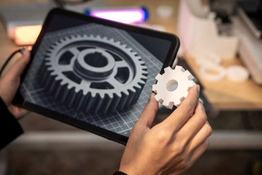 Hands holding a tablet with a gear icon and a white gear piece, showing technology setup, automation, and business process concept in a blurred office.