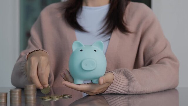Savings and finance concept. woman putting money coin in piggy bank for financial planning and investment.
