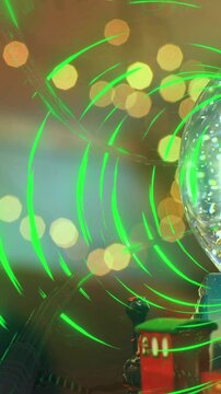 Animation of light spots over snow globe with christmas tree