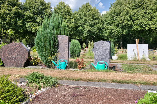 R&uuml;ckseite von Grabsteinen mit dahinter stehenden Gie&szlig;kannen auf dem Hauptfriedhof in M&uuml;lheim Ruhr