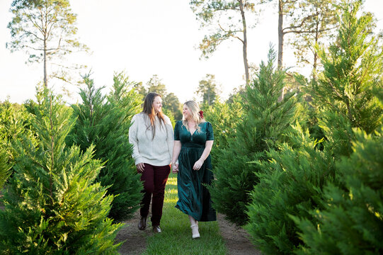 Happy lesbian couple walking at a Christmas tree farm