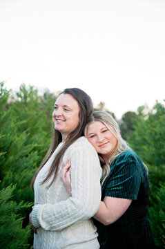 Happy female couple embracing outdoors at a tree farm