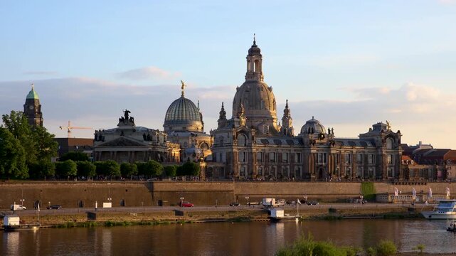 Panoramic sunset video shows Dresden skyline beside Elbe, with Frauenkirche, historic domes and baroque riverfront in golden light. Slow panorama captures architecture, bridge and evening mood