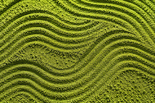 Vibrant green matcha powder macro texture with swept zen garden patterns