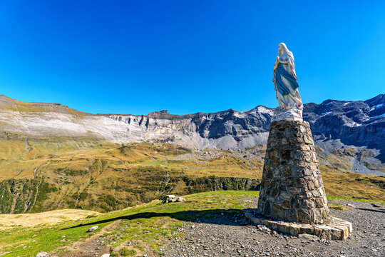 Blessed virgin Mary statue at Cirque de Troumouse, Heas in France. Meadows surrounded by dramatic mountain peaks