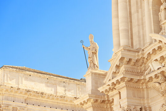 grand stone facade religious building classical columns ornate carvings and prominent sculpture of pope