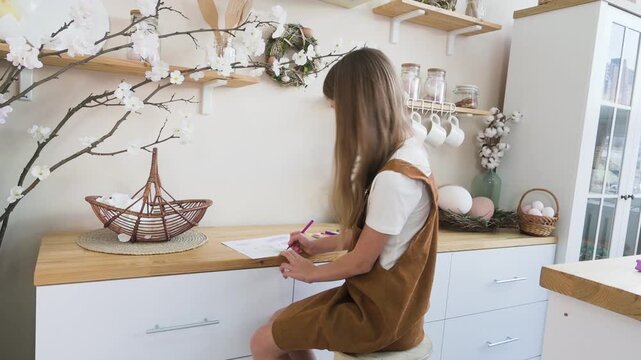 Creative Young Girl Drawing with Colorful Markers at Kitchen Counter with Easter Decor
