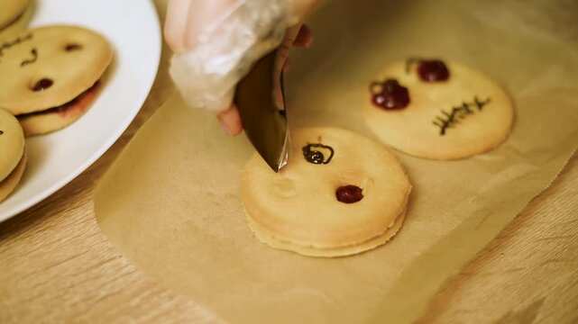 Macro video of drawing a spooky face on a shortbread cookie with chocolate